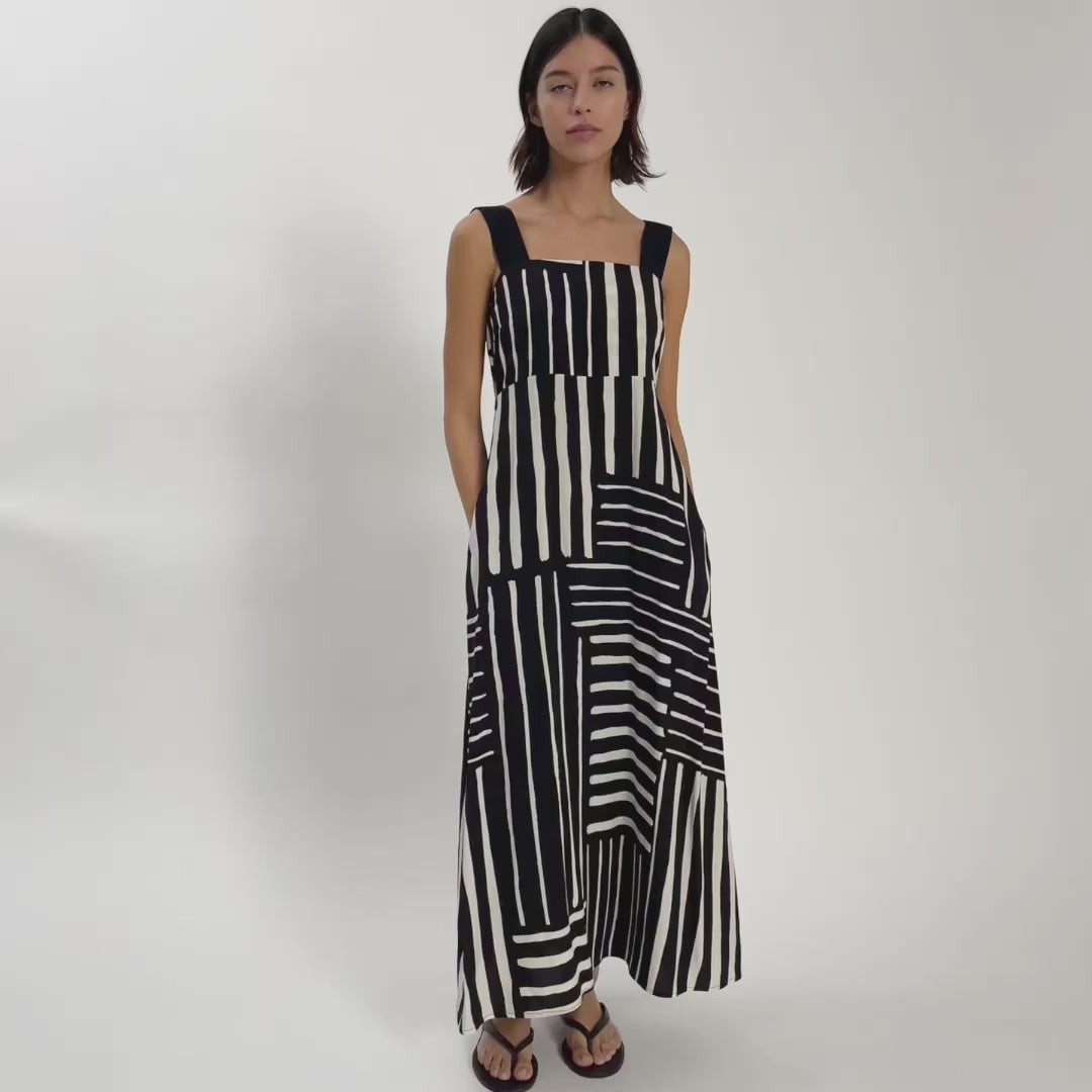 Video of woman wearing black and white print dress with black staps.