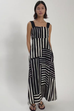 Video of woman wearing black and white print dress with black staps.