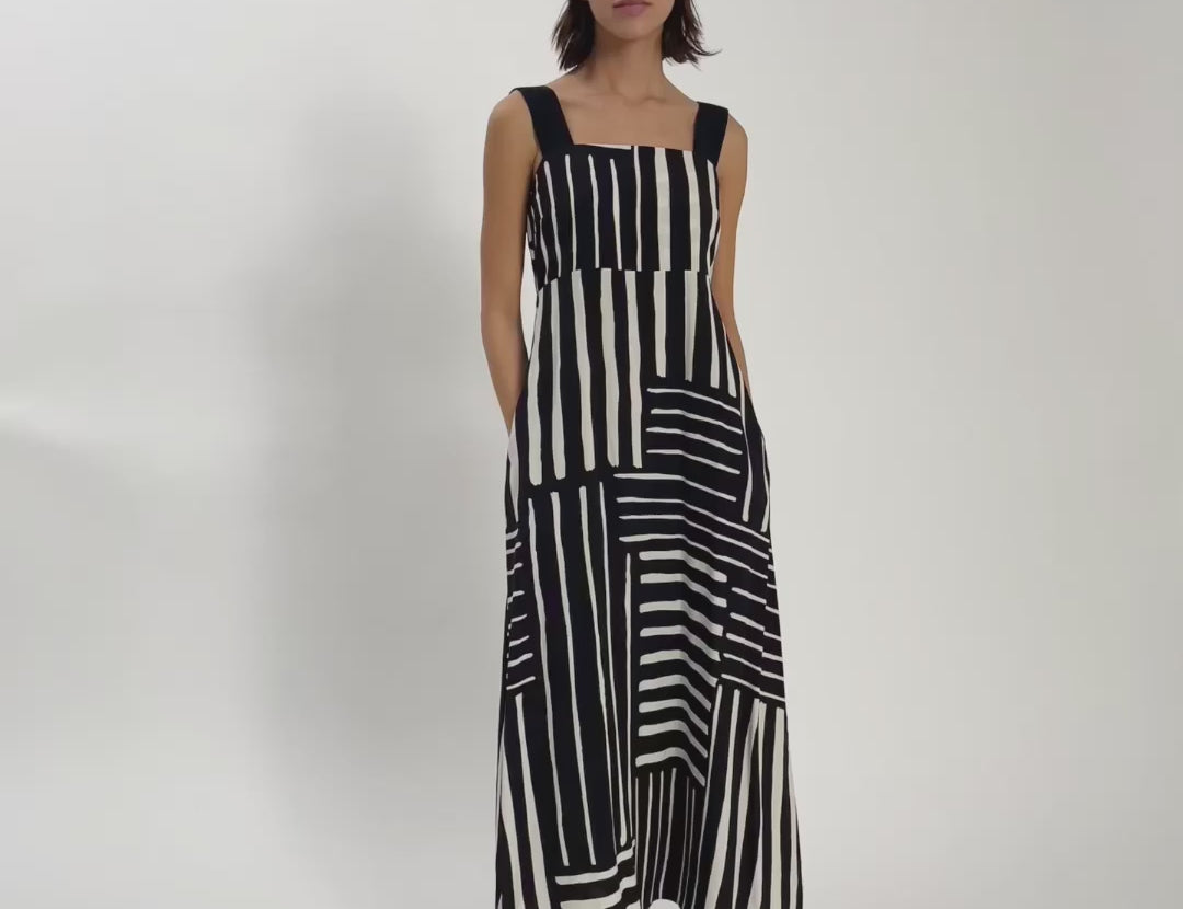 Video of woman wearing black and white print dress with black staps.