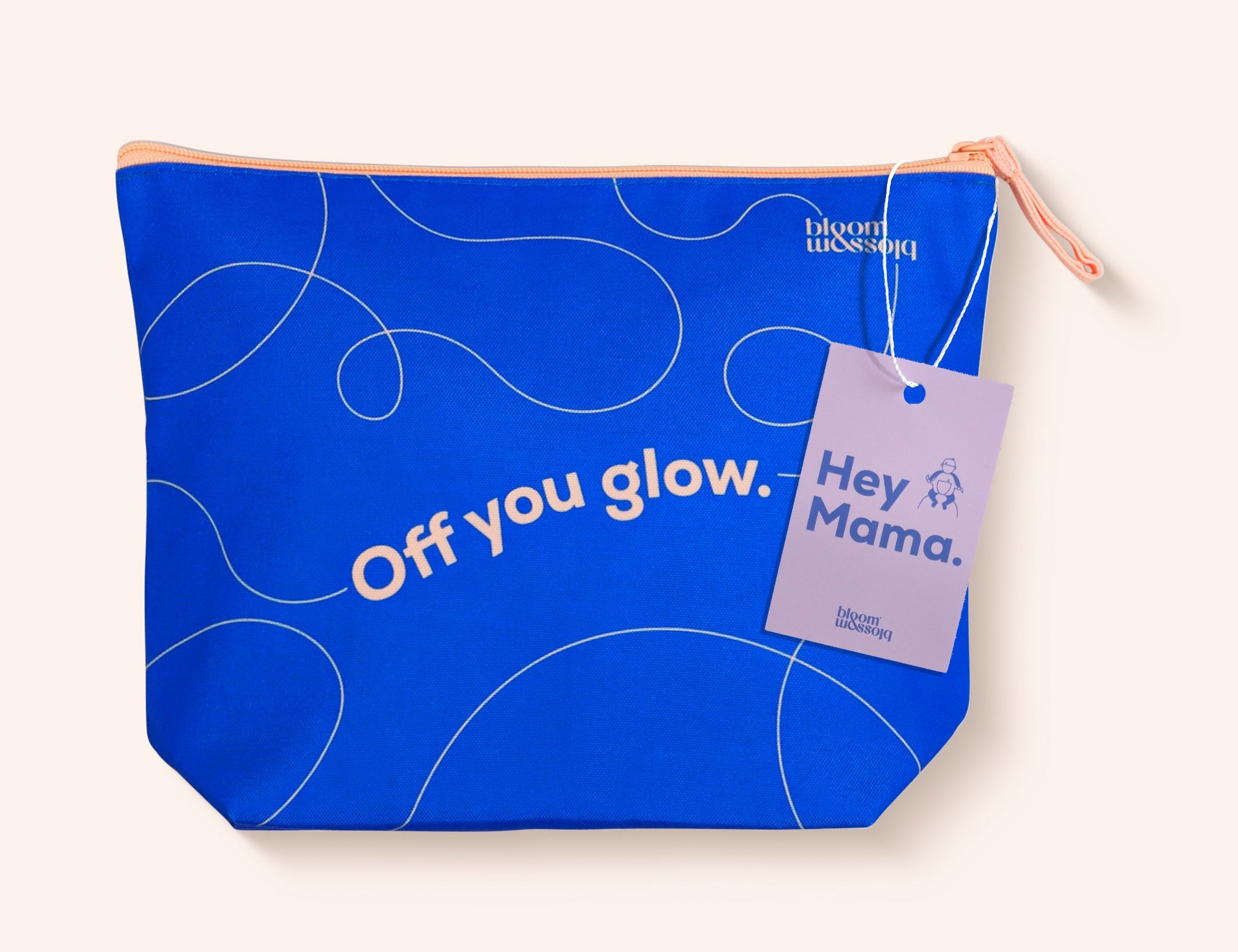 A bright blue zippered pouch with white abstract line drawings and the text 'Off you glow.' on the front, featuring a lavender hangtag that reads 'Hey Mama.