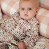 Beatrice Rose Stripe baby nightie close up of ruffled sleeve and floral stripe print on baby resting against cushions