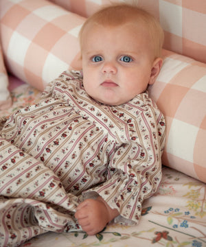 Beatrice Rose Stripe baby nightie close up of ruffled sleeve and floral stripe print on baby resting against cushions