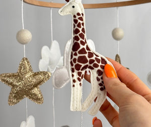 Safari Dreams Felt Cot Mobile with a hand holding the felt giraffe, showing its brown patches and stitched edges