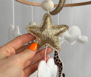 Safari Dreams Felt Cot Mobile with a hand holding a gold glitter star and a white cloud, close up