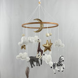 Safari Dreams Felt Cot Mobile hanging from a wooden arm and round wooden music box, full view against a pale backdrop