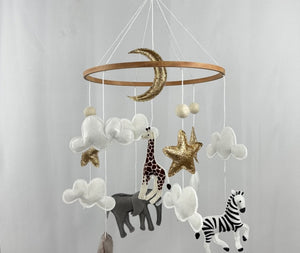 Safari Dreams Felt Cot Mobile hanging from a wooden arm and round wooden music box, full view against a pale backdrop