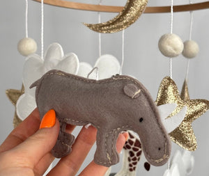 Safari Dreams Felt Cot Mobile with a hand holding the grey-brown felt rhino with stitched edges