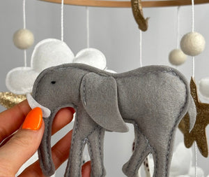 Safari Dreams Felt Cot Mobile with a hand holding the grey felt elephant with a white tusk and stitched edges