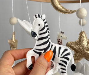 Safari Dreams Felt Cot Mobile with a hand holding the black and white felt zebra in a prancing pose