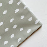 Splash Mat Sage Spots, close-up of the folded corner showing white hand-drawn spots on sage green