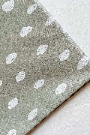 Splash Mat Sage Spots, close-up of the folded corner showing white hand-drawn spots on sage green