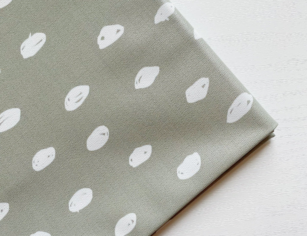 Splash Mat Sage Spots, close-up of the folded corner showing white hand-drawn spots on sage green