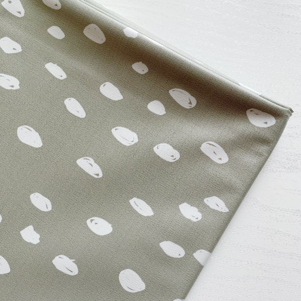 Splash Mat Sage Spots, angled close-up of the folded edge and the white spot print