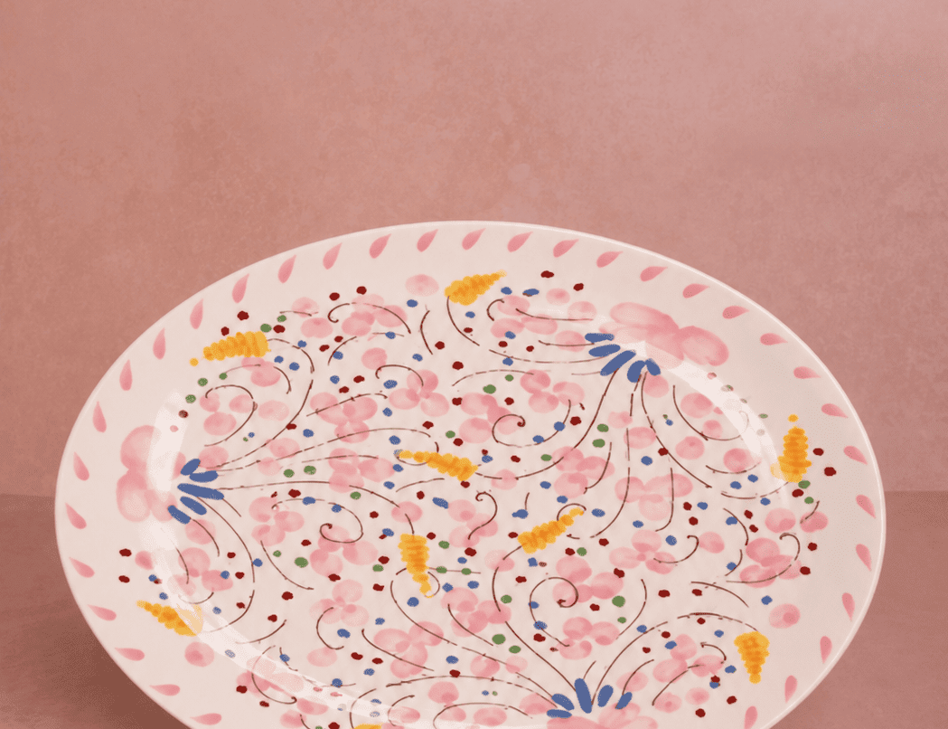 Springtime Meadow Oval Serving Plate with a hand-painted pink floral pattern and pink petal border on a pink backdrop