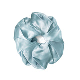 A single light blue satin hair scrunchie on a solid white background.