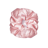 A single light pink satin hair scrunchie centered on a plain white background.