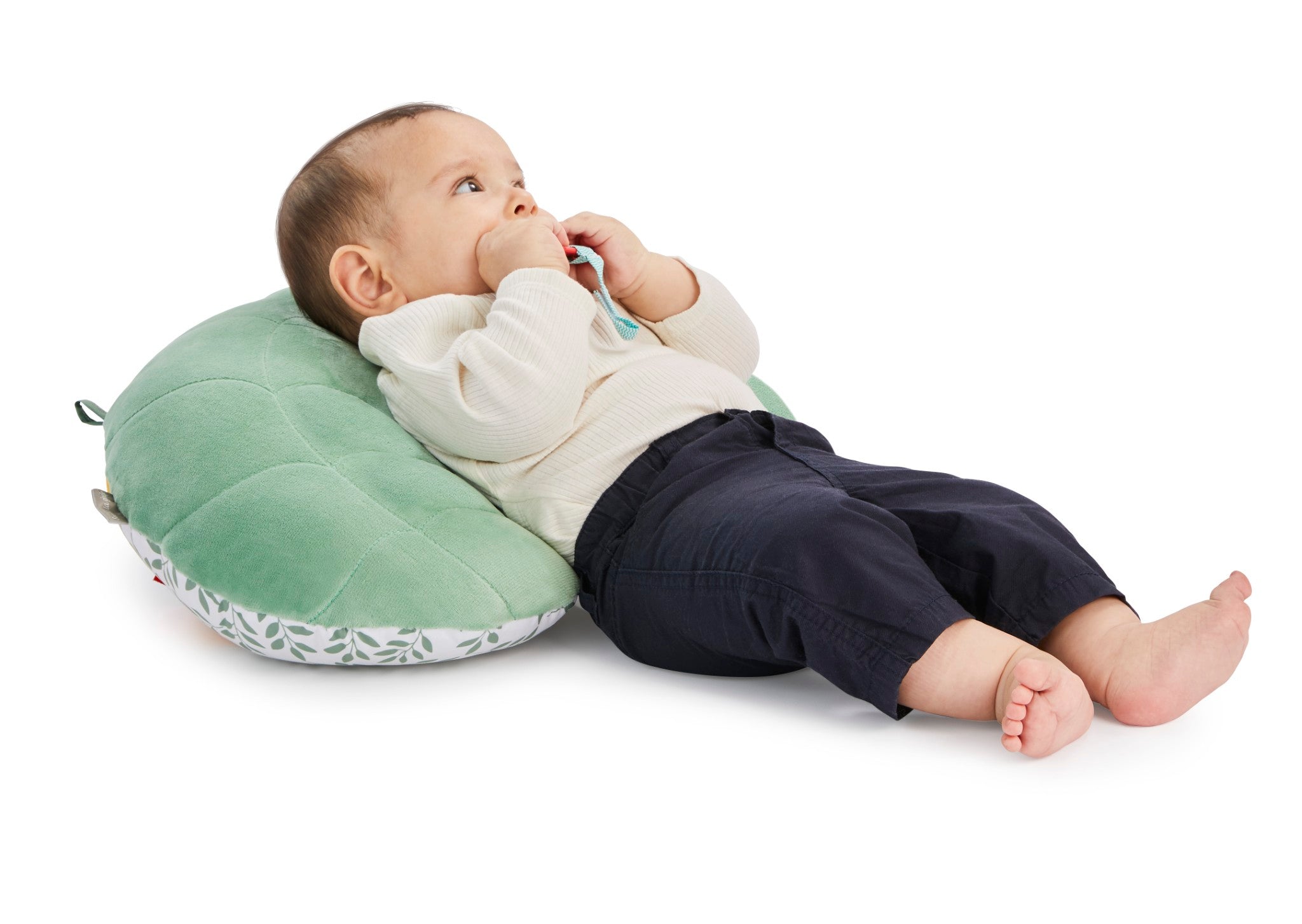 Sophie la girafe Cosy Play Cushion, baby reclining against the plain green quilted back of the cushion