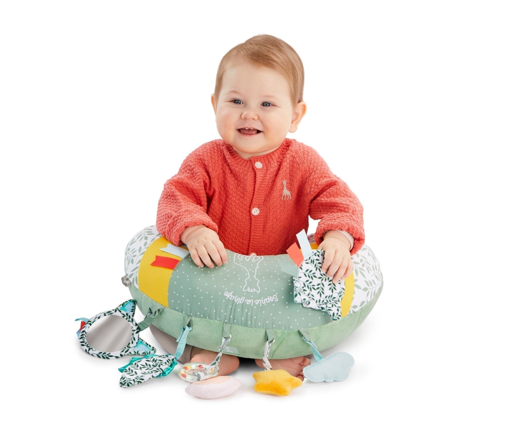 Sophie la girafe Cosy Play Cushion, smiling baby sitting inside the cushion with hands resting on top