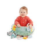 Sophie la girafe Cosy Play Cushion, smiling baby sitting inside the cushion with hands resting on top