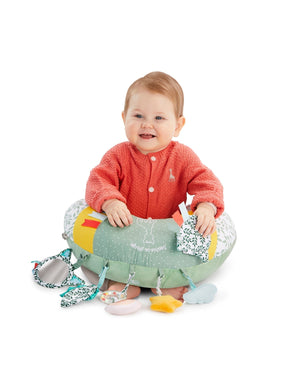 Sophie la girafe Cosy Play Cushion, smiling baby sitting inside the cushion with hands resting on top