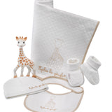Sophie la girafe My Birth Outfit Gift Set laid out: giraffe toy, quilted blanket, hat, bib and booties