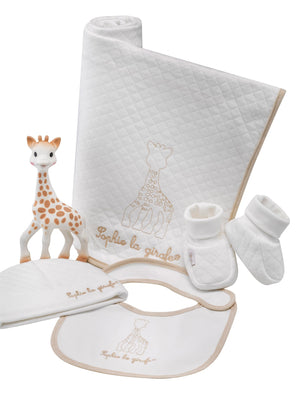 Sophie la girafe My Birth Outfit Gift Set laid out: giraffe toy, quilted blanket, hat, bib and booties
