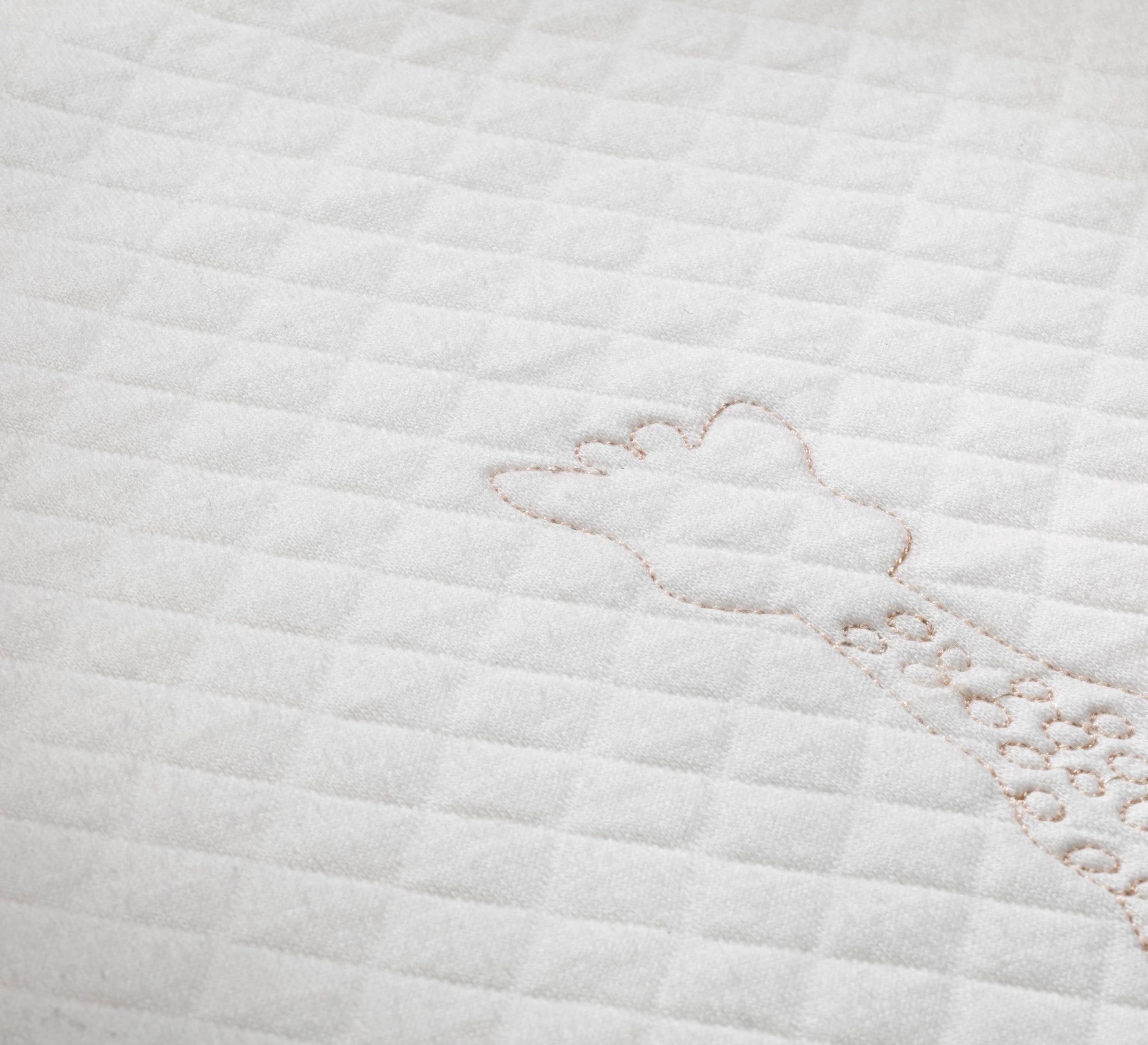 Sophie la girafe My Birth Outfit Gift Set close-up of quilted fabric with embroidered giraffe outline stitching