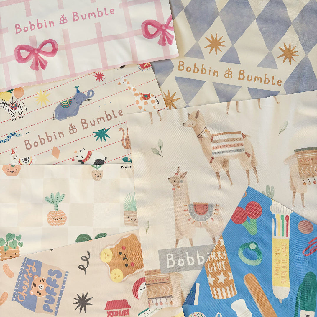 Splash mats in a range of prints laid out together, including pink bow, llamas, Pot Plants and stationery