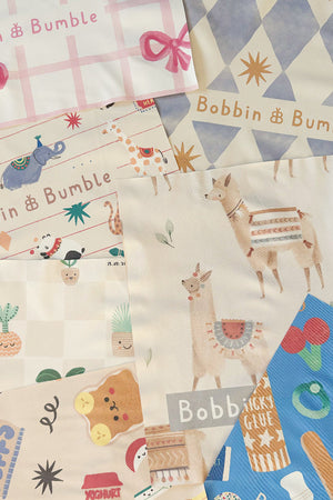Splash mats in a range of prints laid out together, including pink bow, llamas, Pot Plants and stationery