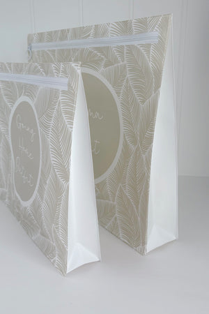 Hospital bag organiser pouches, beige leaf, side view of two standing pouches showing the white expanding side gusset