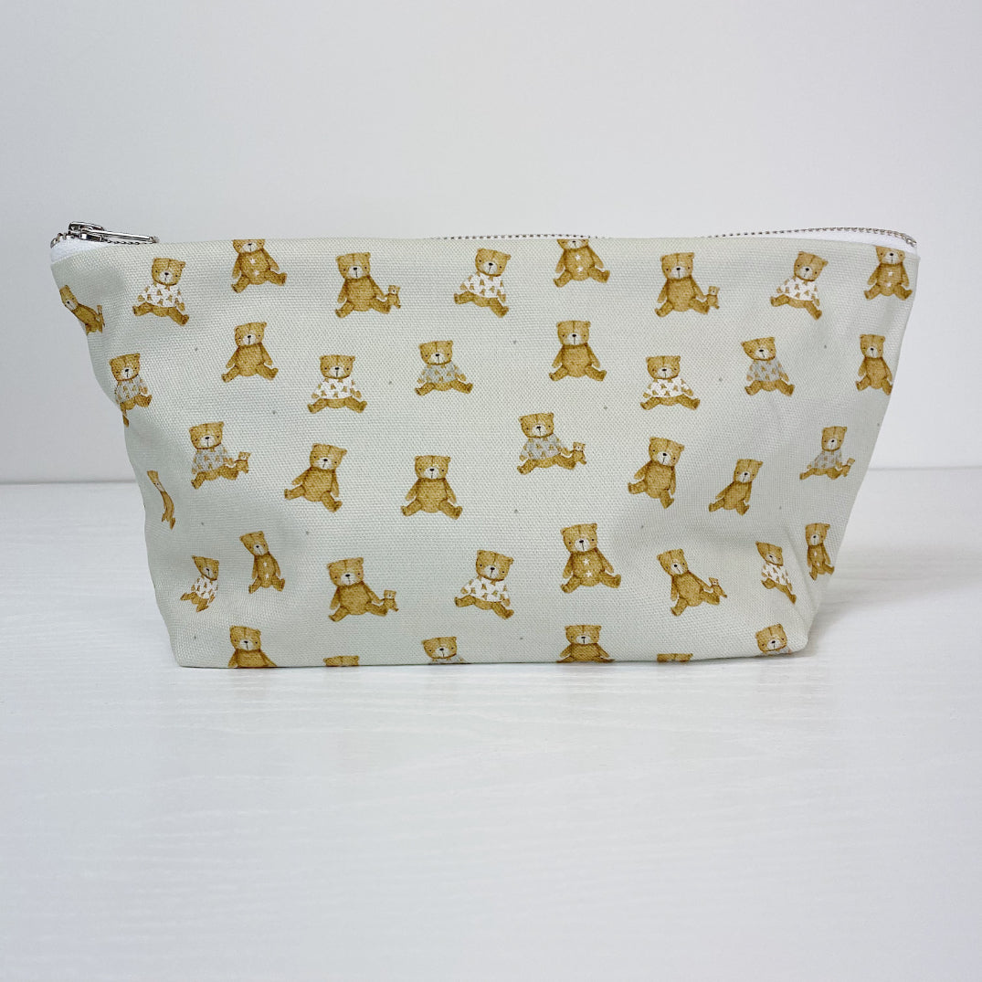 Teddy Bear Print nappy wallet, front view of the zipped pouch covered in small seated teddy bears on a pale background