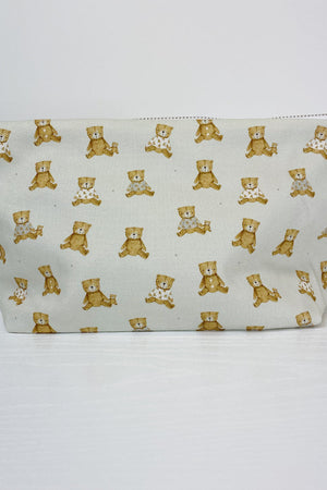 Teddy Bear Print nappy wallet, front view of the zipped pouch covered in small seated teddy bears on a pale background