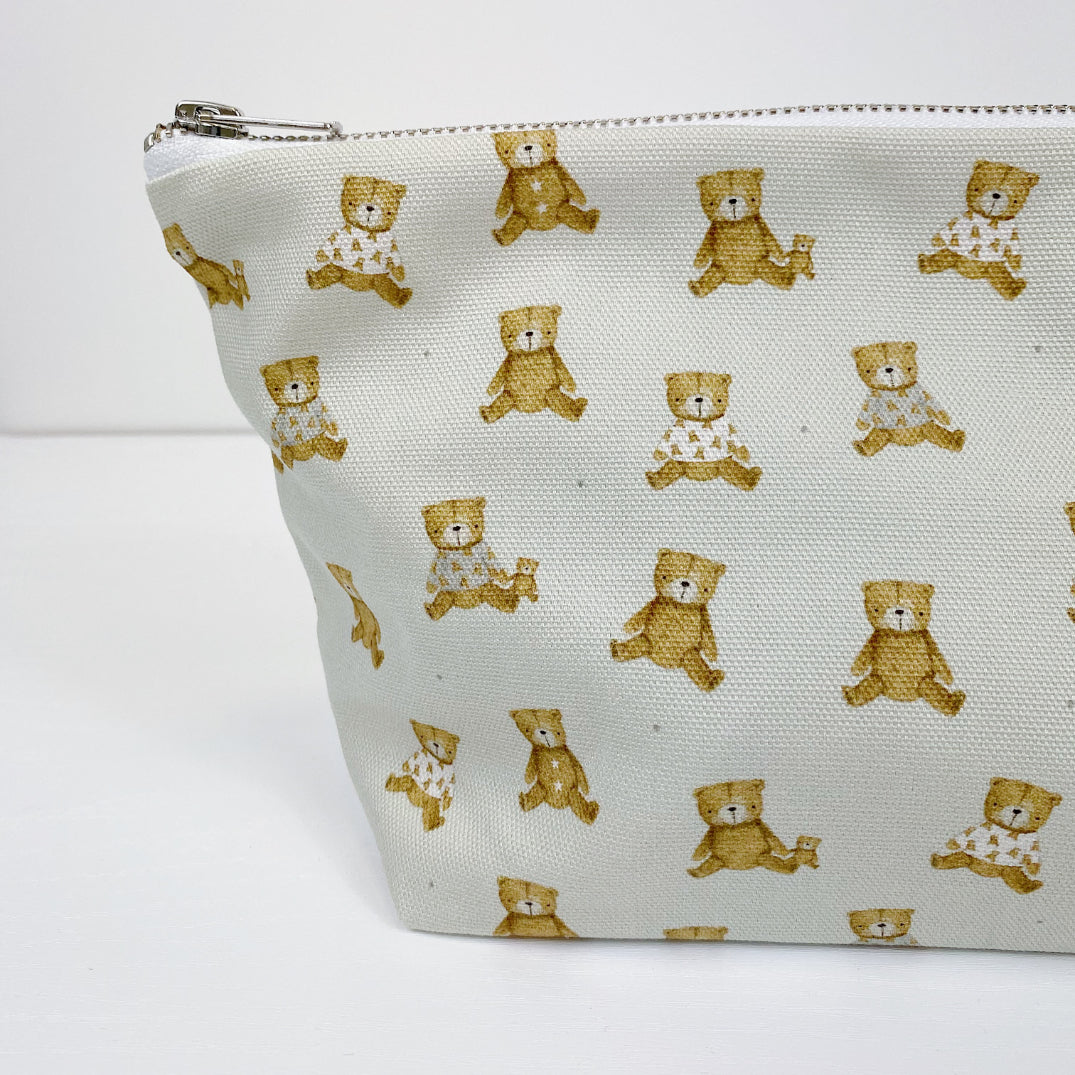 Teddy Bear Print nappy wallet, close-up of the teddy bear print, some bears wearing patterned tops, with zip at top
