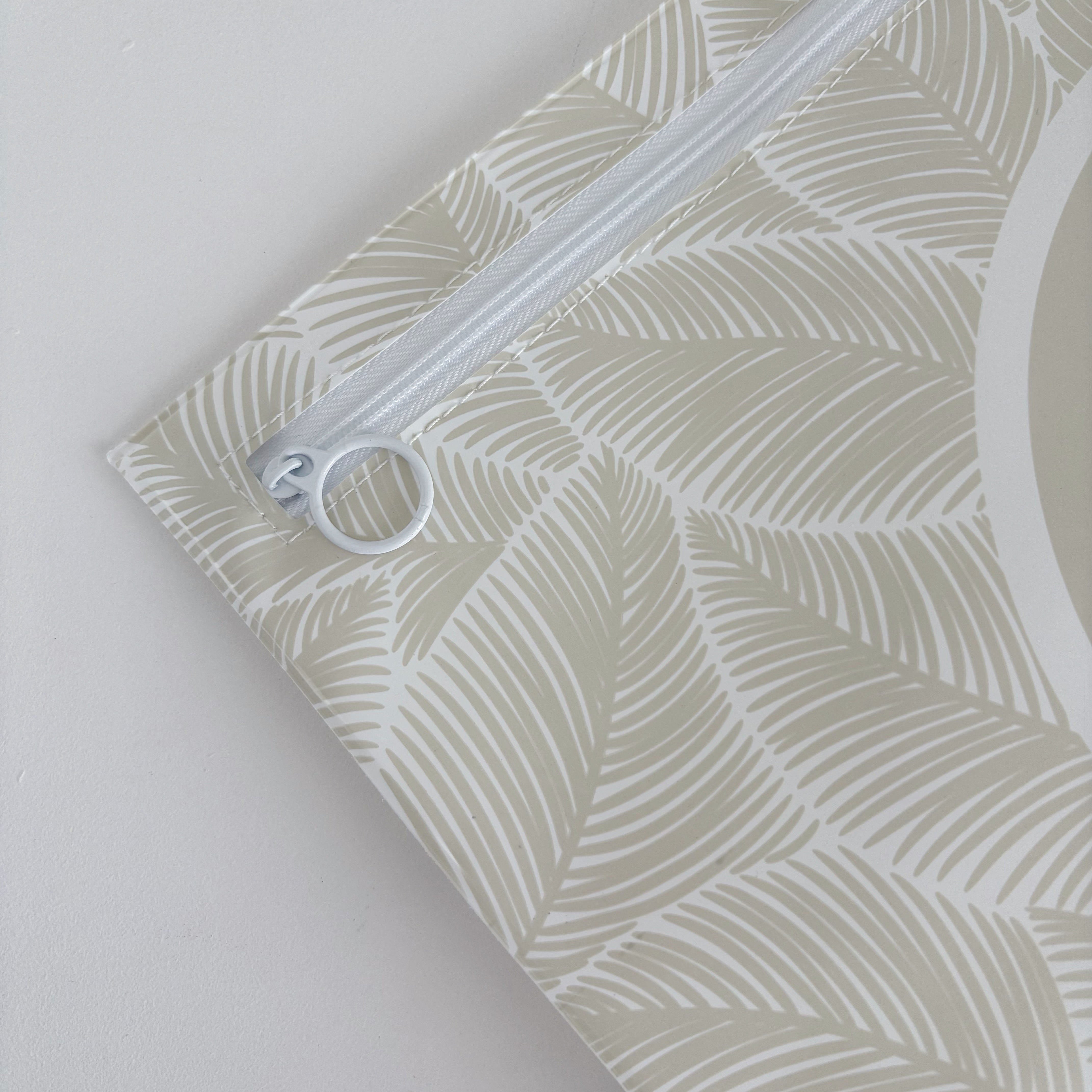 Hospital bag organiser pouches, beige leaf, close-up of the white zip and ring pull in the corner of a pouch